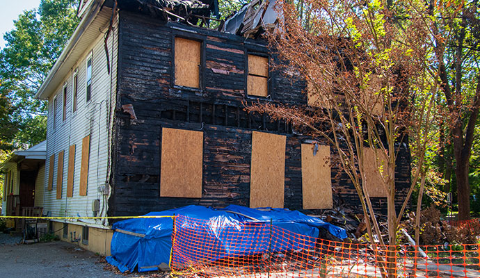 Boarded-up fire-damaged house