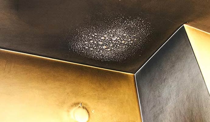 Ceiling with severe soot damage and burn marks around a light fixture