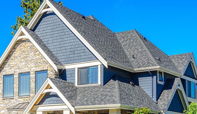 Close-up view of a modern house exterior featuring a gray shingle roof