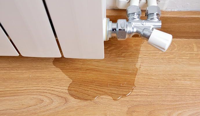 Wooden floor damaged by water leak from plumbing issue